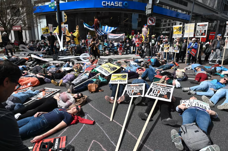 Climate activists take part in a “die-in” this month outside a Chase Bank location in Washington, D.C. (Matt McClain/The Washington Post)
